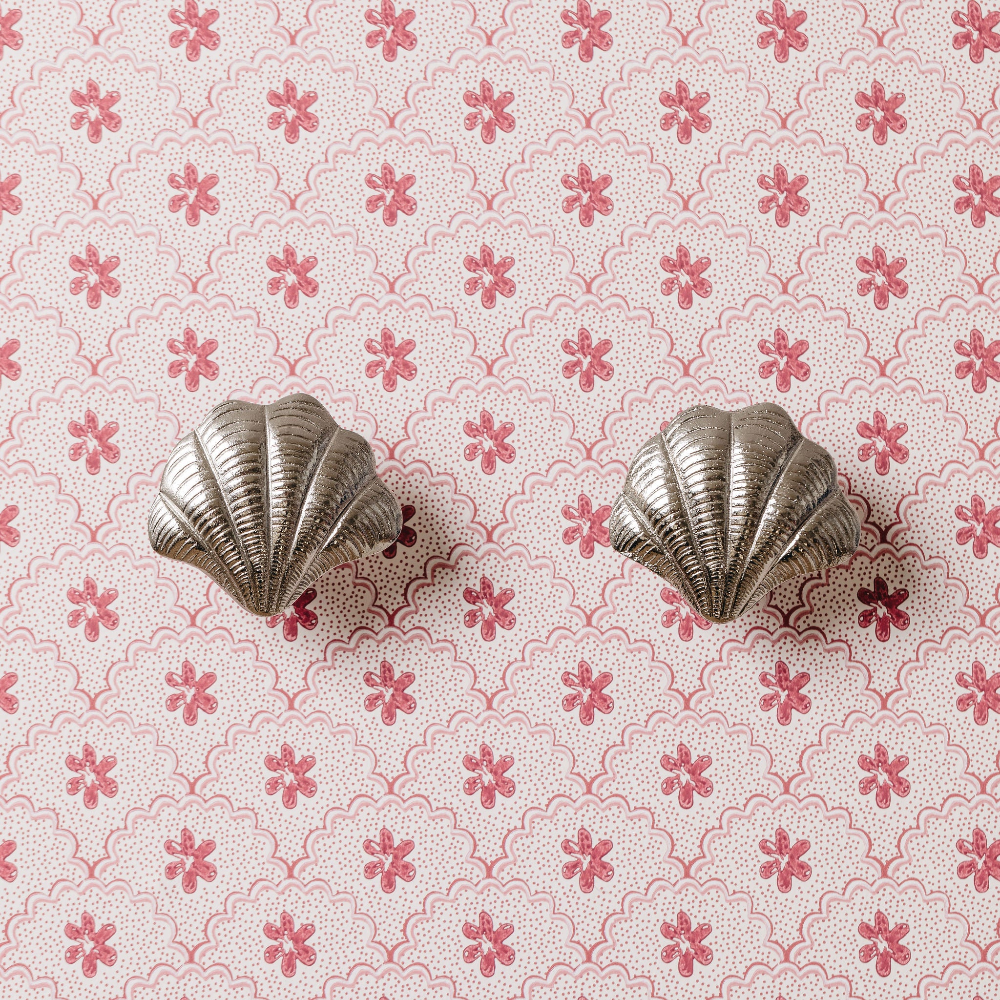 Silver shell-shaped knob on a pink floral patterned background