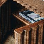 Wicker shelf with a book titled 'Modern Upholstery' on a textured surface