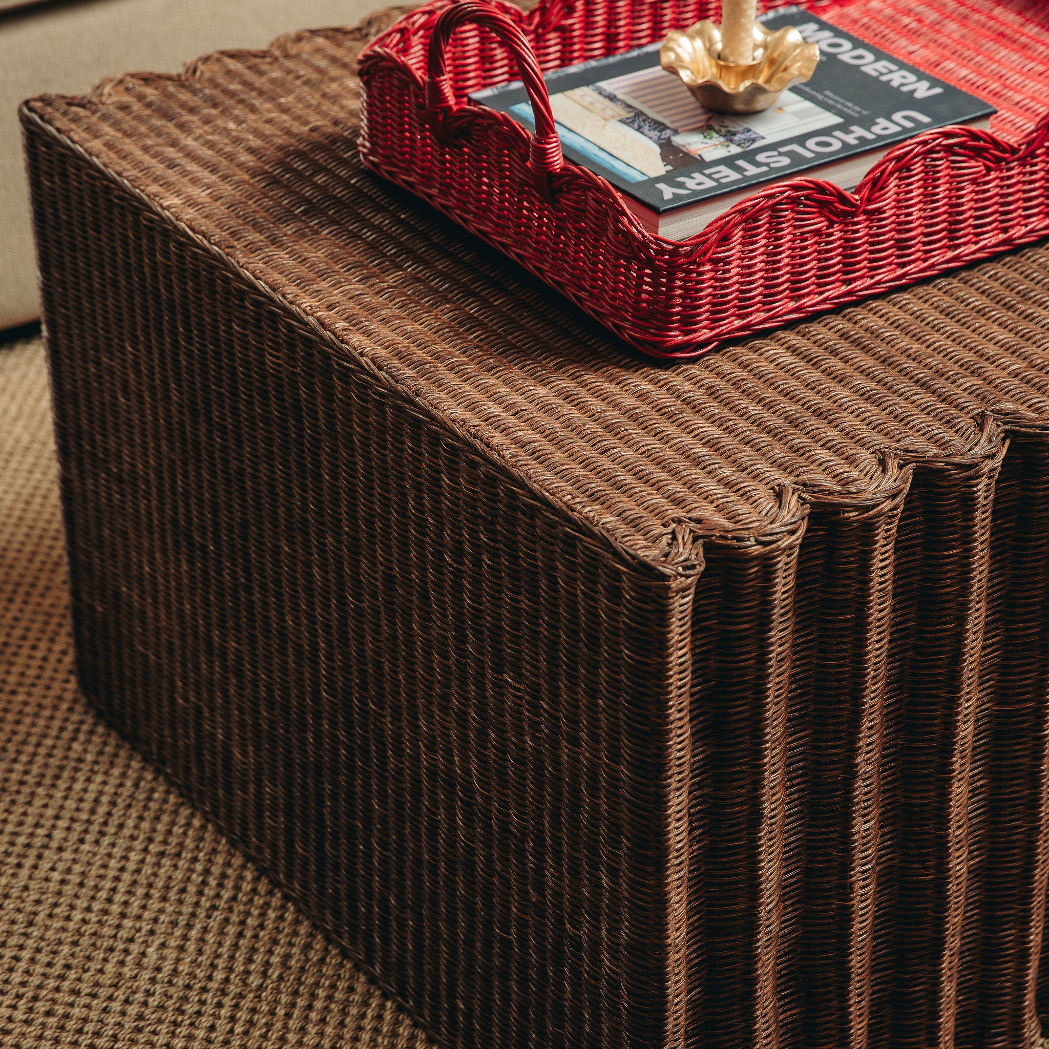 Daisy Brown woven ottoman with a red tray and book on top