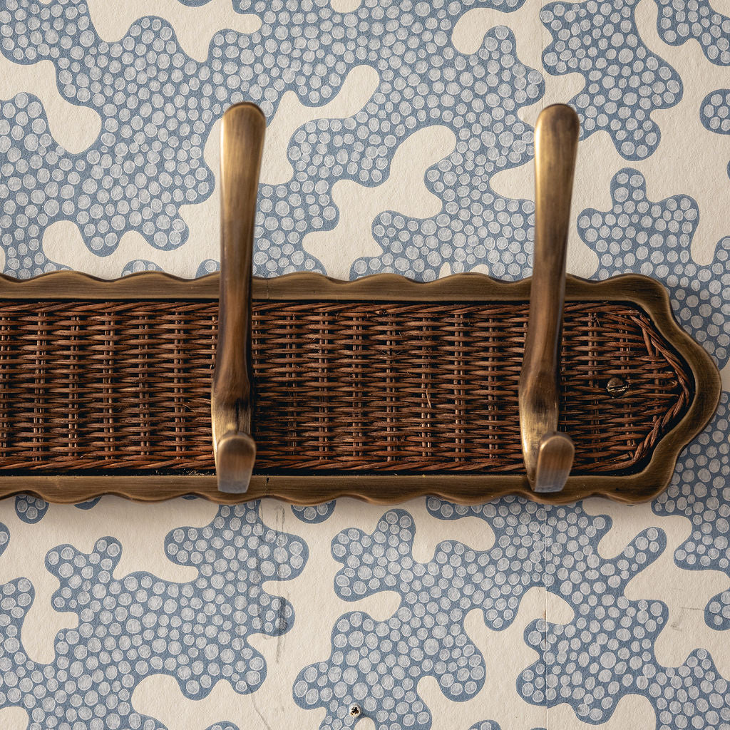 Wicker tray with brass handles on a patterned background