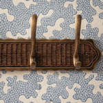 Wicker tray with brass handles on a patterned background