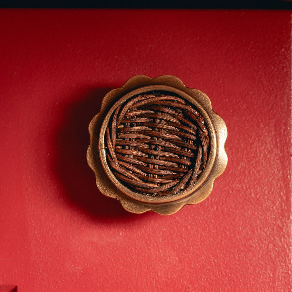 Delilah Round Knob Teak, Aged Brass on red background