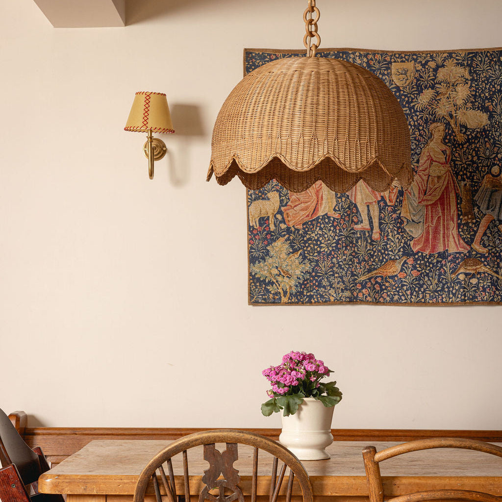 Dining room with wooden table, chairs, and a tapestry on the wall.