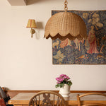 Dining room with wooden table, chairs, and a tapestry on the wall.