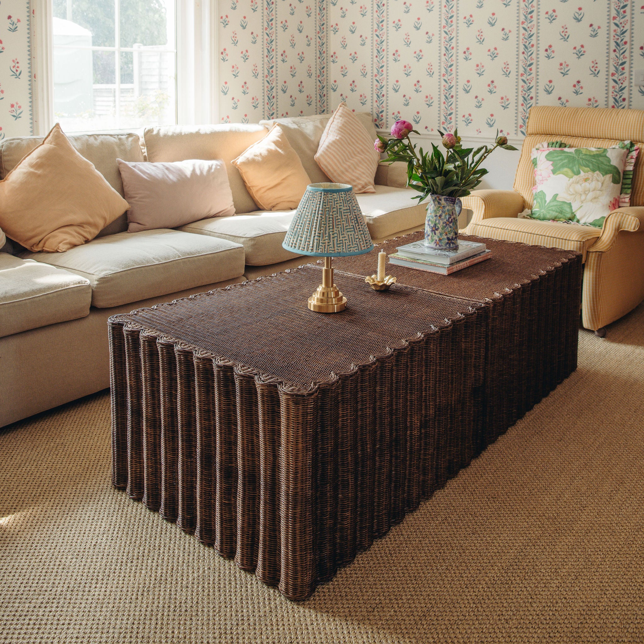 Living room with a brown wicker coffee table, beige sofa, and armchair.