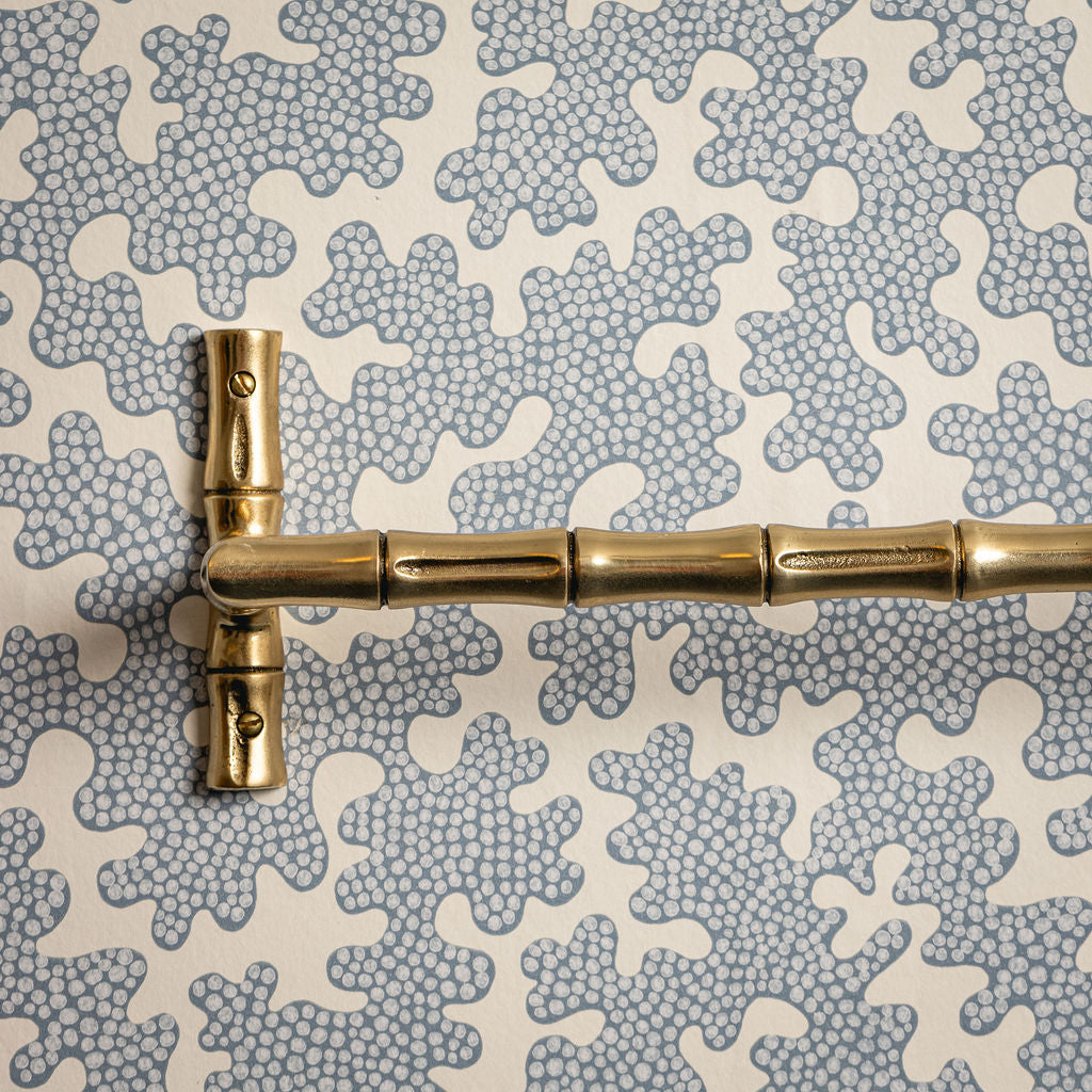 Gold bamboo-style handle on a textured gray and white background