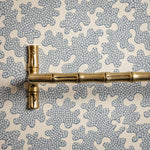 Gold bamboo-style handle on a textured gray and white background