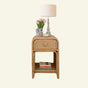Phoenix Wicker side table with lamp, flowers, and books on a white background